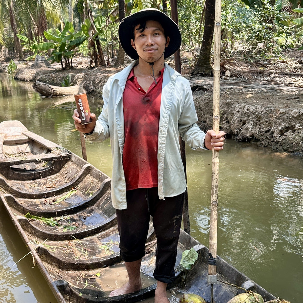 Bootsfahrer im Mekong-Delta mit einer Cocodo Dose